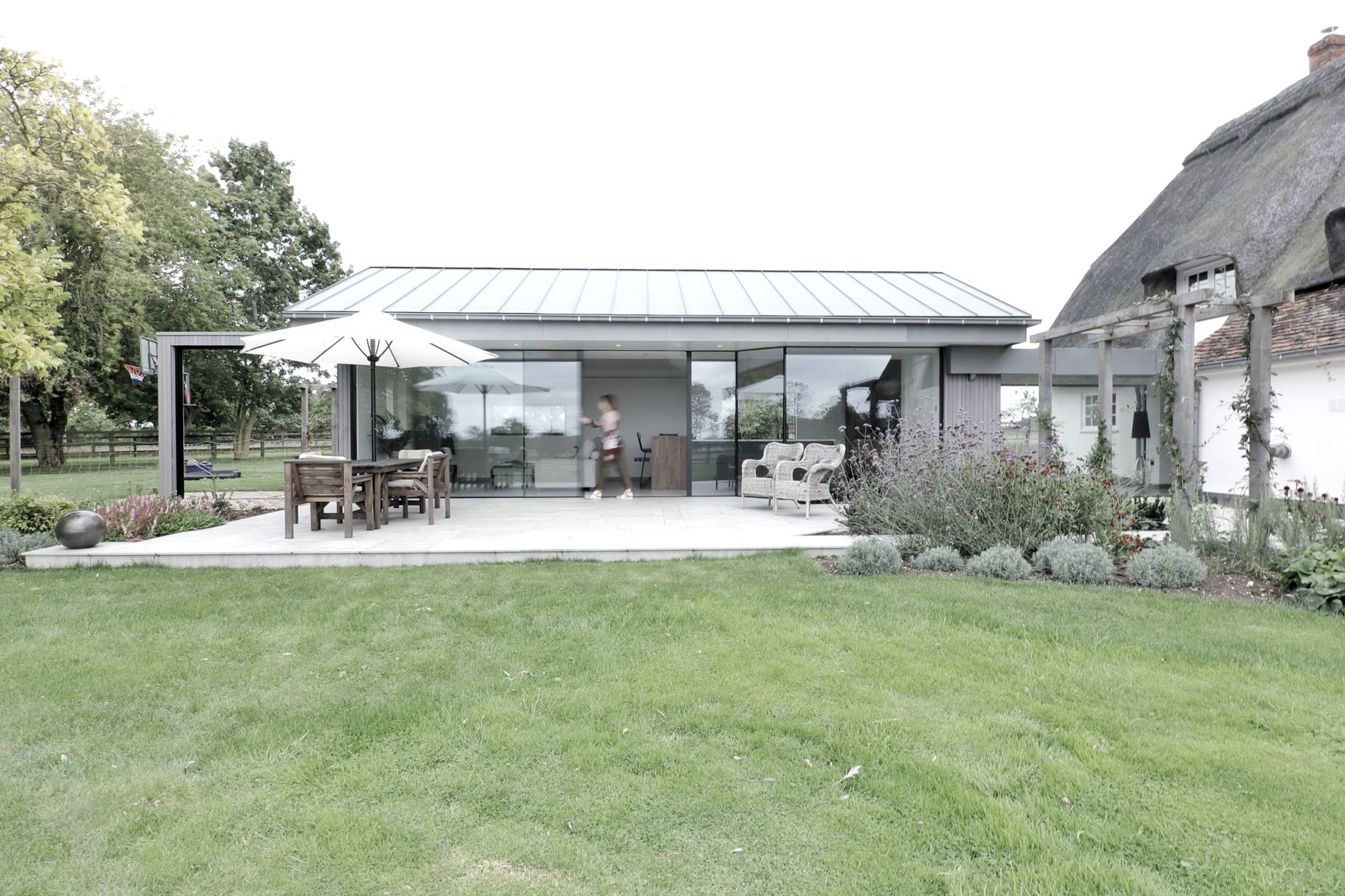 Contemporary annex beside Grade II listed thatched farmhouse, Suffolk